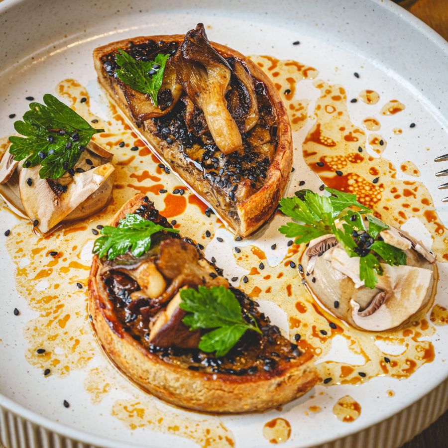 Tartes fines aux champignons dressées sur une assiette blanche