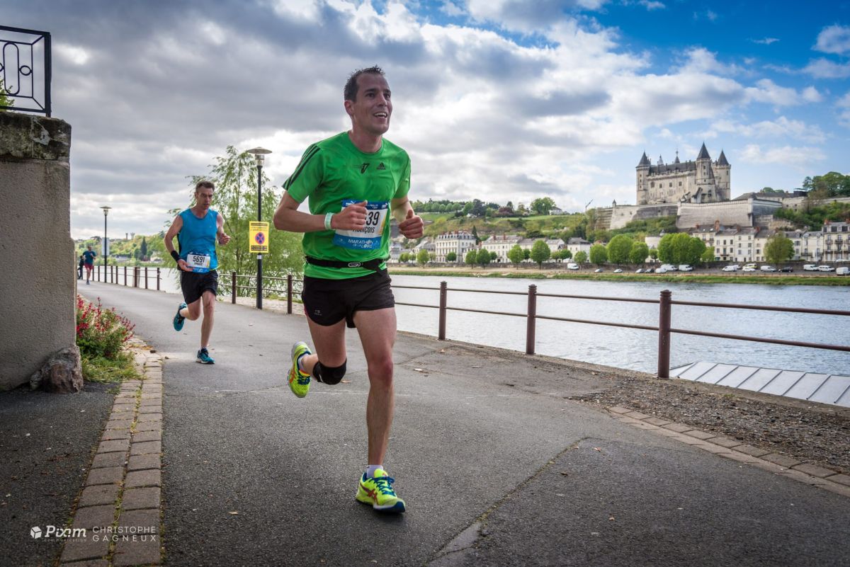 Coureur du Marathon de la Loire sur les quais, le château de Saumur en arrière-plan