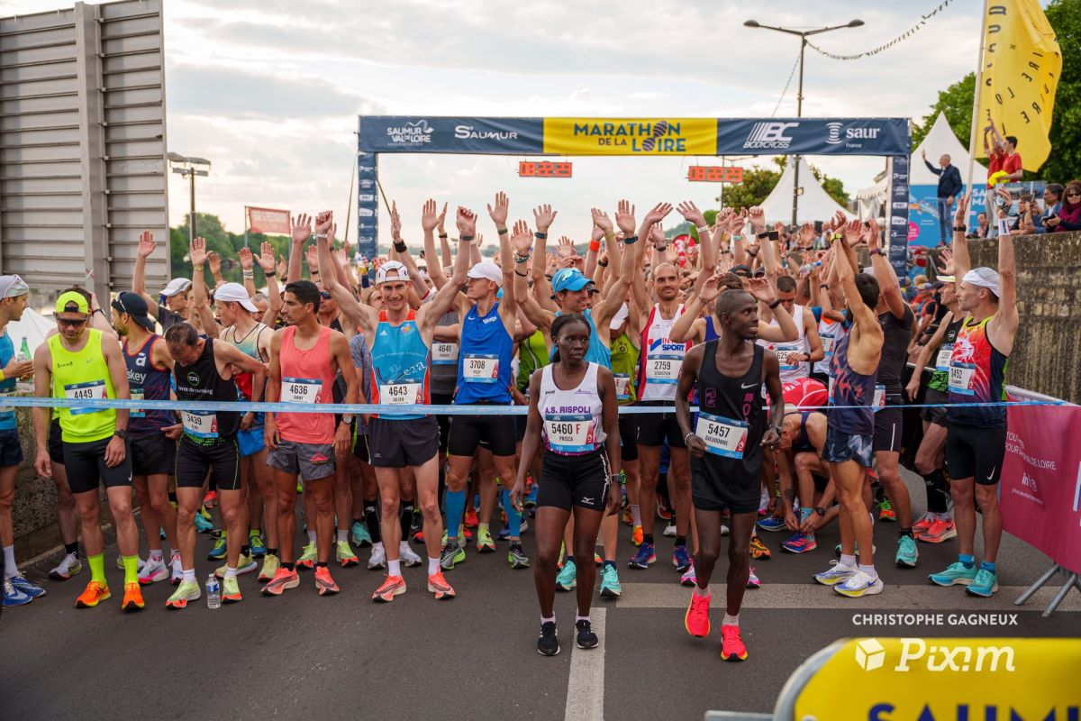 Coureurs sur la ligne de départ du Marathon de la Loire, bras levés