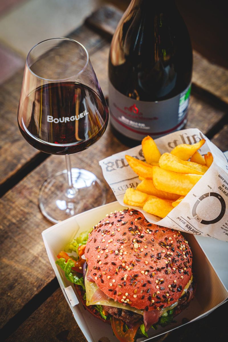 Accord mets-vins photographié par Pixim pour les réseaux sociaux des Vins de Bourgueil : un verre de vin rouge, un burger et des frites