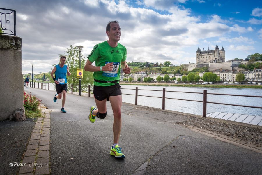 Coureur du Marathon de la Loire sur les quais, le château de Saumur en arrière-plan
