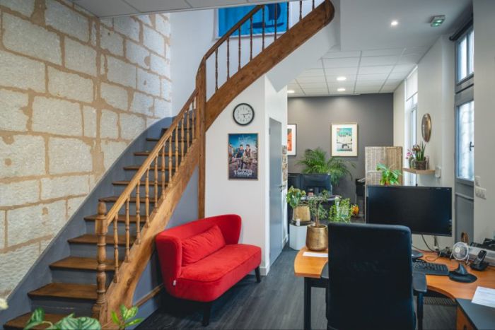 L’espace d’accueil des bureaux de Pixim à Saumur, avec son escalier et son canapé rouge